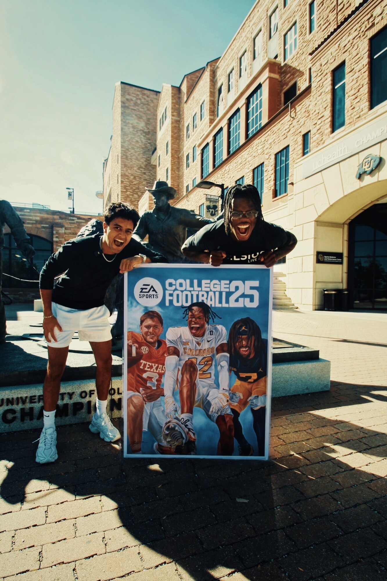Kyan Patel and a friend leaning over one of his football paintings outdoors